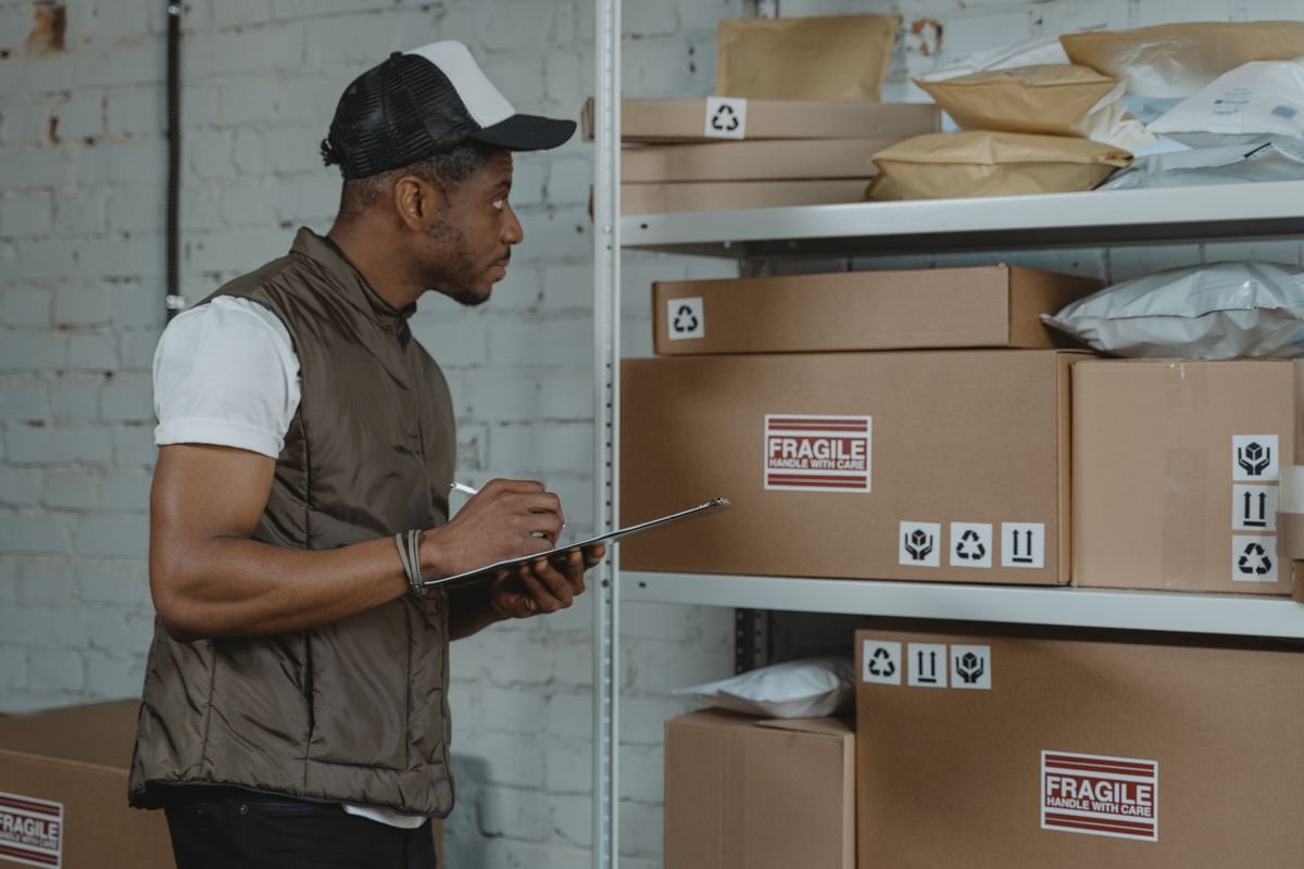 Warehouse worker checking cartons with a clipboard